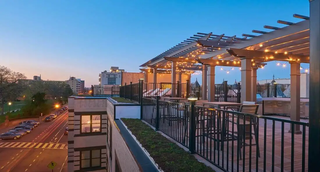 Metal railing around a commercial rooftop patio at dusk