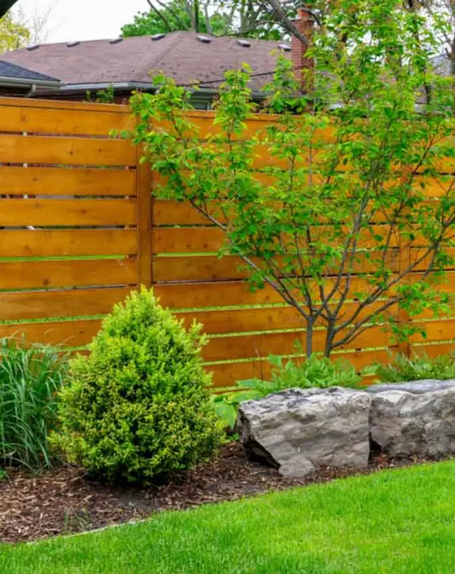 Horizontal wood privacy fence with landscaping